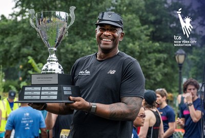 Ted Metellus holds a trophy at NYRR Team Championships